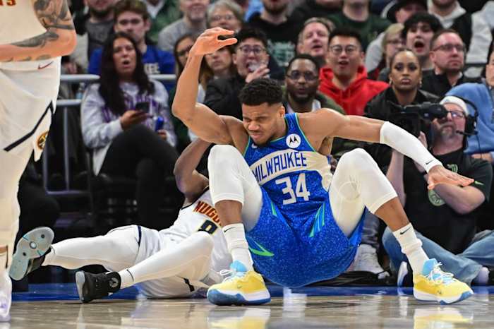Milwaukee Bucks forward Giannis Antetokounmpo (34) falls after colliding with Denver Nuggets forward Peyton Watson (8)